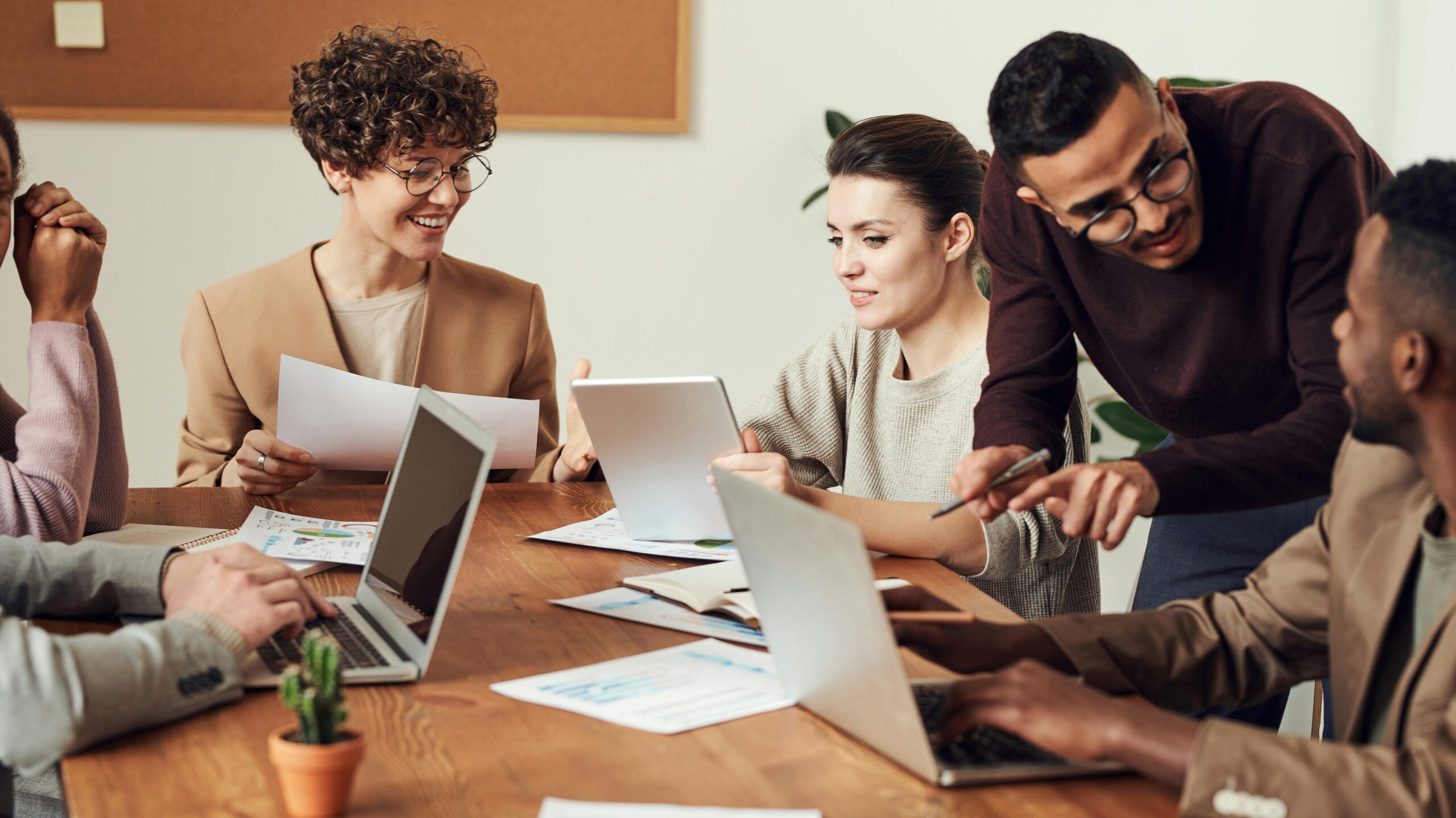 A diverse group of professionals engaged in a collaborative office meeting, sharing ideas and discussing projects.